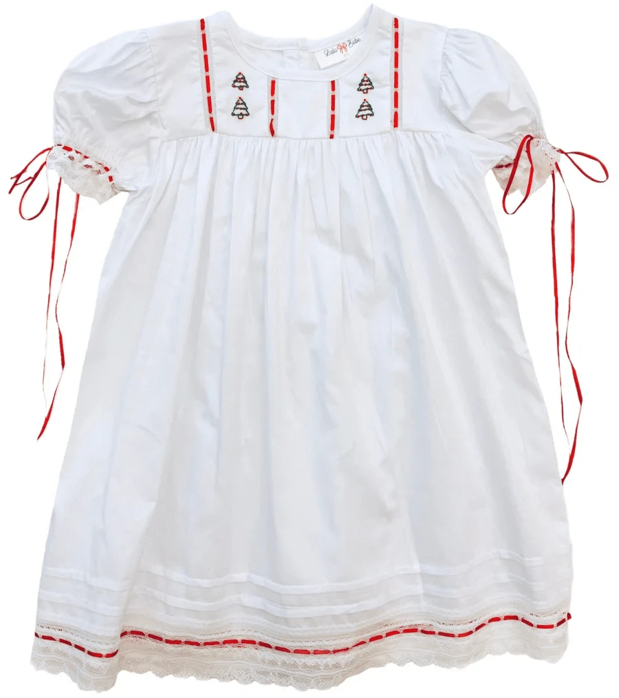girls white dress with red ribbon and christmas trees