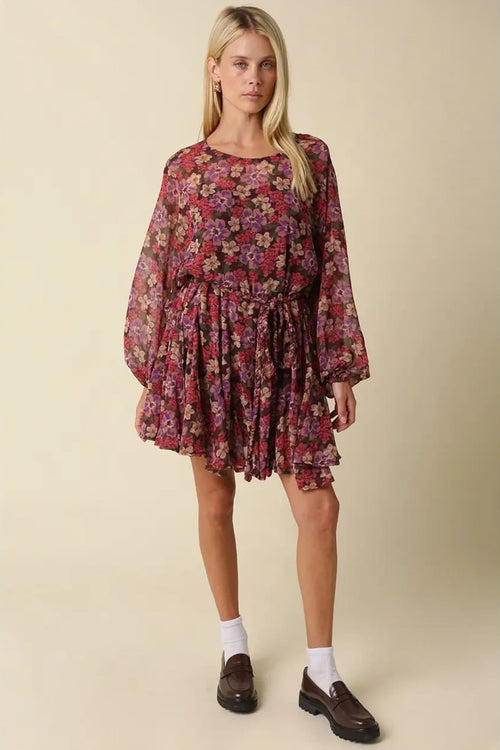 Model wearing the Emily burgundy floral mini dress with brown loafers and white socks